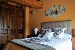 1 dormitorio con 1 cama grande con almohadas blancas en LA FUENTE DE CABANILLAS, en Cabanillas del Monte