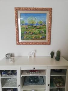 een schilderij aan een muur boven een witte kast bij Le terrazze segrete in Palermo +18 foto's