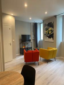 a living room with three chairs and a television at Quai St Paul in Ancenis