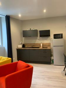 a kitchen with an orange chair and a white refrigerator at Quai St Paul in Ancenis