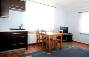 a kitchen with a table and chairs in a room at Leniuchowo in Junoszyno