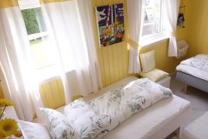 a room with a bed and two windows and a couch at Risør Bed & Breakfast, Randvik Strand in Risør