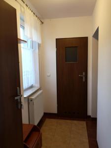a hallway with a wooden door and a window at Pensjonat Markus Grzybowo in Grzybowo +36 photos