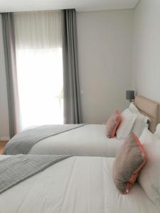 um quarto com 2 camas com almofadas e uma janela em Silver Seahorse Garden Retreat II na Consolação