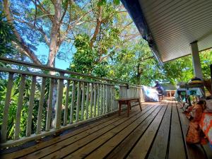 une terrasse en bois avec une table et un banc. dans l'établissement Sweet Mini Dortoir sur notre terrasse couverte pour vos transits entre deux vols by Kohutahia Lodge, 7 min by car to airport and town, à Fa'a'ā