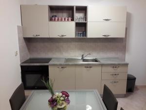 a kitchen with a sink and a table with flowers on it at Apartment Eni in Matulji