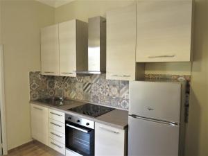 a kitchen with white cabinets and a refrigerator at Casa MELA in Palau