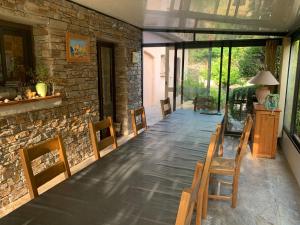 ein Esszimmer mit Stühlen und einer Steinmauer in der Unterkunft Chambres et tables d'hôtes Zélia & Jacques BERQUEZ in Pianottoli-Caldarello