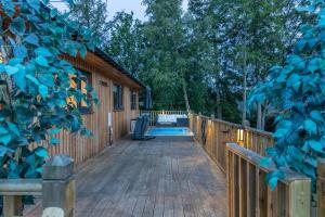 een houten terras met een zwembad en een huis bij Settlers Lodge in Otterburn