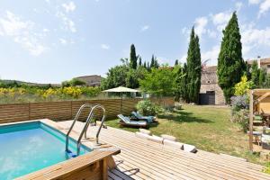 un patio trasero con piscina y terraza de madera en Sant Mori- La Escala Boutique apartment, en Sant Mori