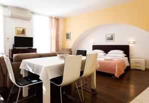 - une chambre avec un lit, une table et des chaises dans l'établissement Apartments Fortezza, à Split