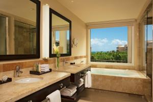 a bathroom with a large tub and a large window at Dreams Jade Resort & Spa - All Inclusive in Puerto Morelos