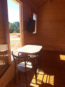 a small table and chairs in a room with a television at Chalet de fred in Saint-Ouen-de-Mimbré