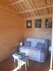 a room with a couch and a table in a cabin at Chalet de fred in Saint-Ouen-de-Mimbré