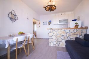 a kitchen and a living room with a table and a couch at Apartments Uskok in Vis