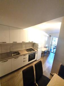 - une cuisine avec des placards blancs, une table et des chaises dans l'établissement Apartment Ana, à Izola