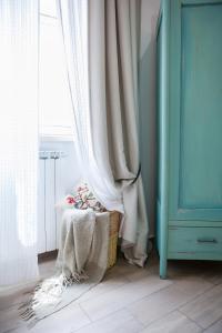 ローマにあるMaison Coquetteの白いカーテン、テーブル、窓が備わる客室です。