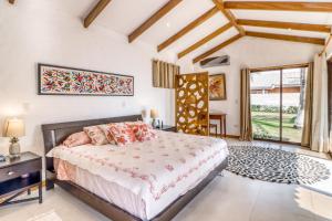 a bedroom with a bed and a large window at Casa La Palapa in Esparza