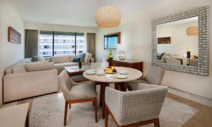 sala de estar con mesa y sofá en Park Royal Beach Cancun - All Inclusive, en Cancún