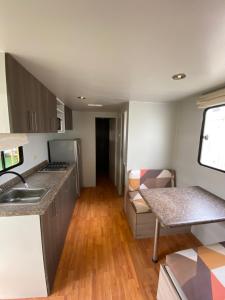a kitchen and living room with a table and a couch at Casa Caravanas in Paracas