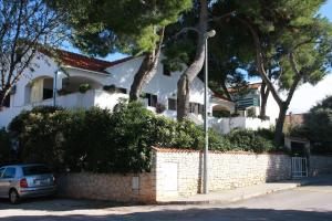 Biały dom z samochodem zaparkowanym przed nim w obiekcie Apartments Brac Mirca w mieście Mirce