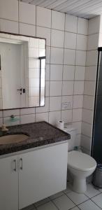 a bathroom with a toilet and a sink and a mirror at Aquaville - Porto das Dunas in Aquiraz