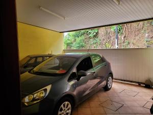 a small car parked in a garage at Sweet Mini Dortoir sur notre terrasse couverte pour vos transits entre deux vols by Kohutahia Lodge, 7 min by car to airport and town in Faaa