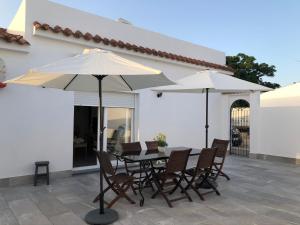 a table and chairs with umbrellas on a patio at Villas Santa Ana in Conil de la Frontera