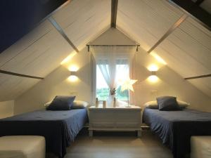 a attic room with two beds and a window at Villas Santa Ana in Conil de la Frontera +149 photos
