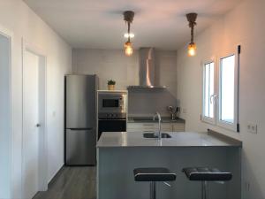 a kitchen with a sink and a refrigerator at Villas Santa Ana in Conil de la Frontera