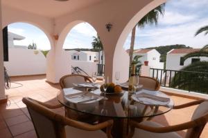 a dining room with a table and chairs on a balcony at Apartamento Albatros-Son Parc Menorca in Son Parc