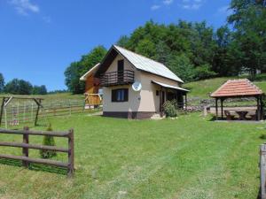 a small house in a field next to a fence at Vikendica Sekulić in Bajina Bašta +15 photos