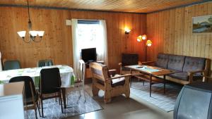 ein Wohnzimmer mit einem Sofa und einem Tisch in der Unterkunft Solheim. Hytte med 2 soverom in Birkenes