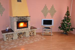 a living room with a fireplace and a christmas tree at Penzion Chalupka in Štrba