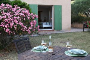 a wooden table with two glasses of wine on it at PantaiaHomes - Clos de Susville - Vue Panoramique - Piscine - Jacuzzi in Tavernes