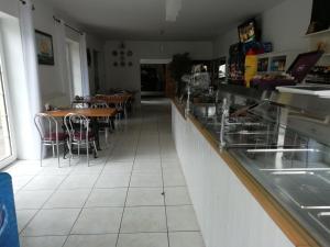 a restaurant with tables and chairs and a counter at Pod Złotym Żaglem in Karwia