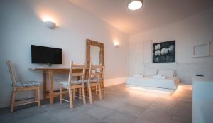 a living room with a television and a table and chairs at ZOE in Apollonia