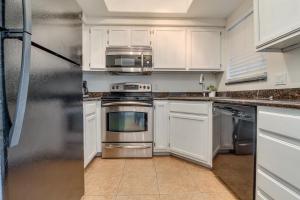 a kitchen with white cabinets and a stainless steel refrigerator at 1 bedroom unit ground floor in Chandler