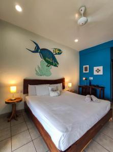 
a bedroom with a bed and a painting on the wall at La Palmita Budget Boutique Hotel in Tulum

