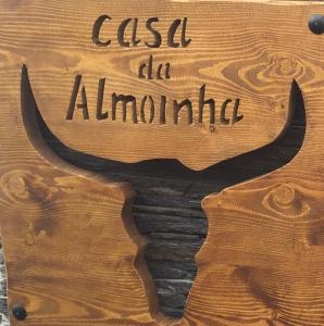 Um sinal que diz "casa ale ammonia" com uma fotografia de um touro. em Casa da Almoinha em Unhais da Serra