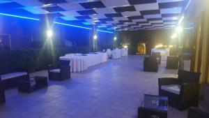Zimmer mit weißen Tischen, Stühlen und blauen Lichtern in der Unterkunft Torre dei Mori Boutique Rooms B&B in Capaccio-Paestum