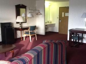 a hotel room with a couch and a table at Super 8 by Wyndham Kennett in Kennett
