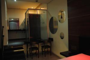 a bathroom with a table and chairs and a mirror at Motel Sunny Day Contagem in Contagem