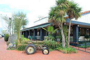 a cart sitting in front of a building with palm trees at Casa de Fruta Inn in Hollister