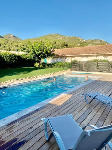 una piscina con terraza y sillón en Le Provence, en Gémenos