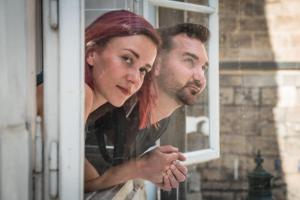 a man and a woman looking out of a window at Charles Bridge Hostel & Apartments in Prague