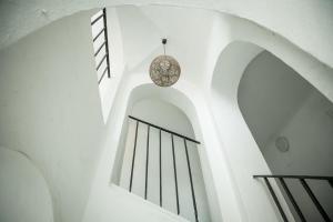 una escalera con paredes blancas y una lámpara de araña en Charles Bridge Hostel & Apartments en Praga