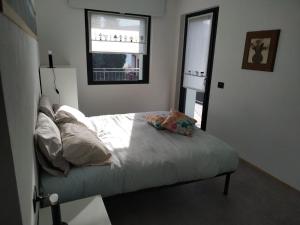 una camera da letto con letto, cuscini e finestra di Mountain Holidays B&B a Rovetta