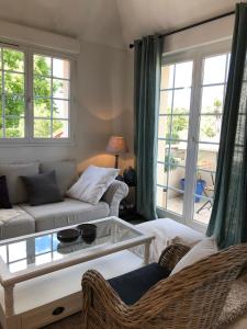 a living room with a couch and a glass table at Les terrasses ensoleillées de Carteret in Barneville-Carteret