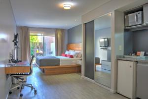 a bedroom with a bed and a desk with a chair at Rambla Apartamentos in Montevideo